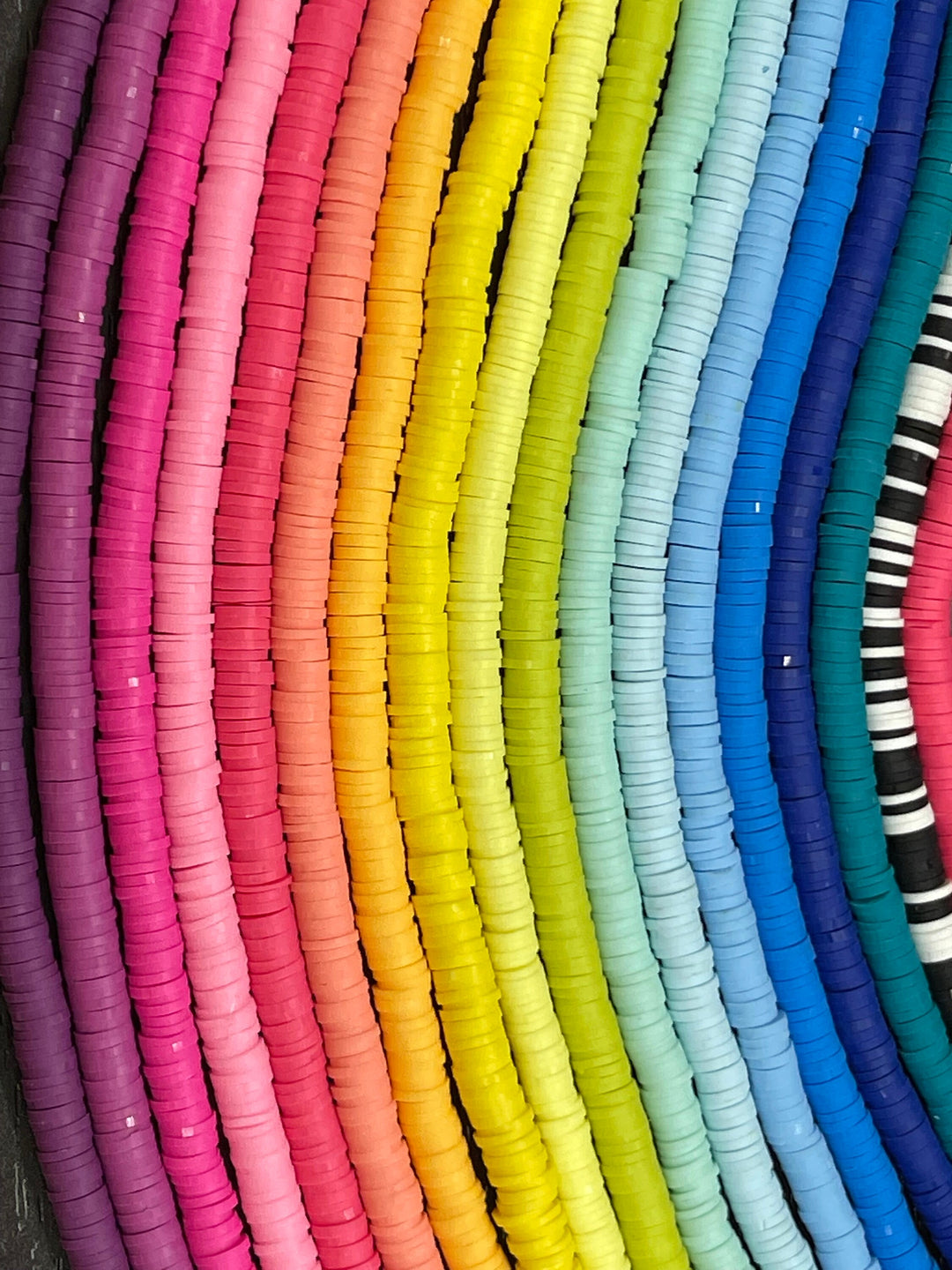 a rainbow colored wall with a bunch of different colored frisbees