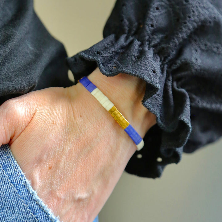 a person wearing a blue and yellow bracelet