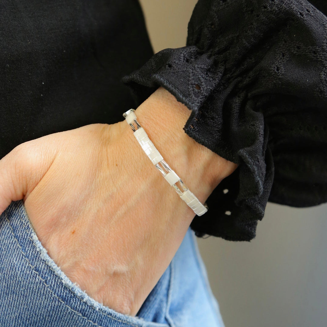 a woman's hand wearing a silver bracelet