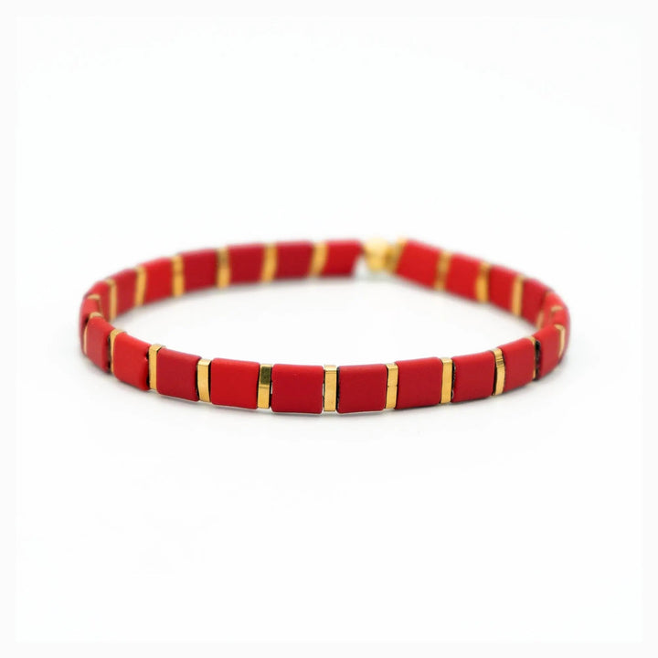 a red and gold bracelet on a white background