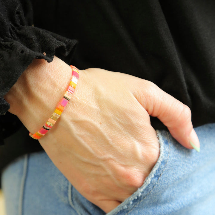 a woman wearing a colorful bracelet and a black shirt