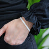 a person wearing a white bracelet with a black shirt